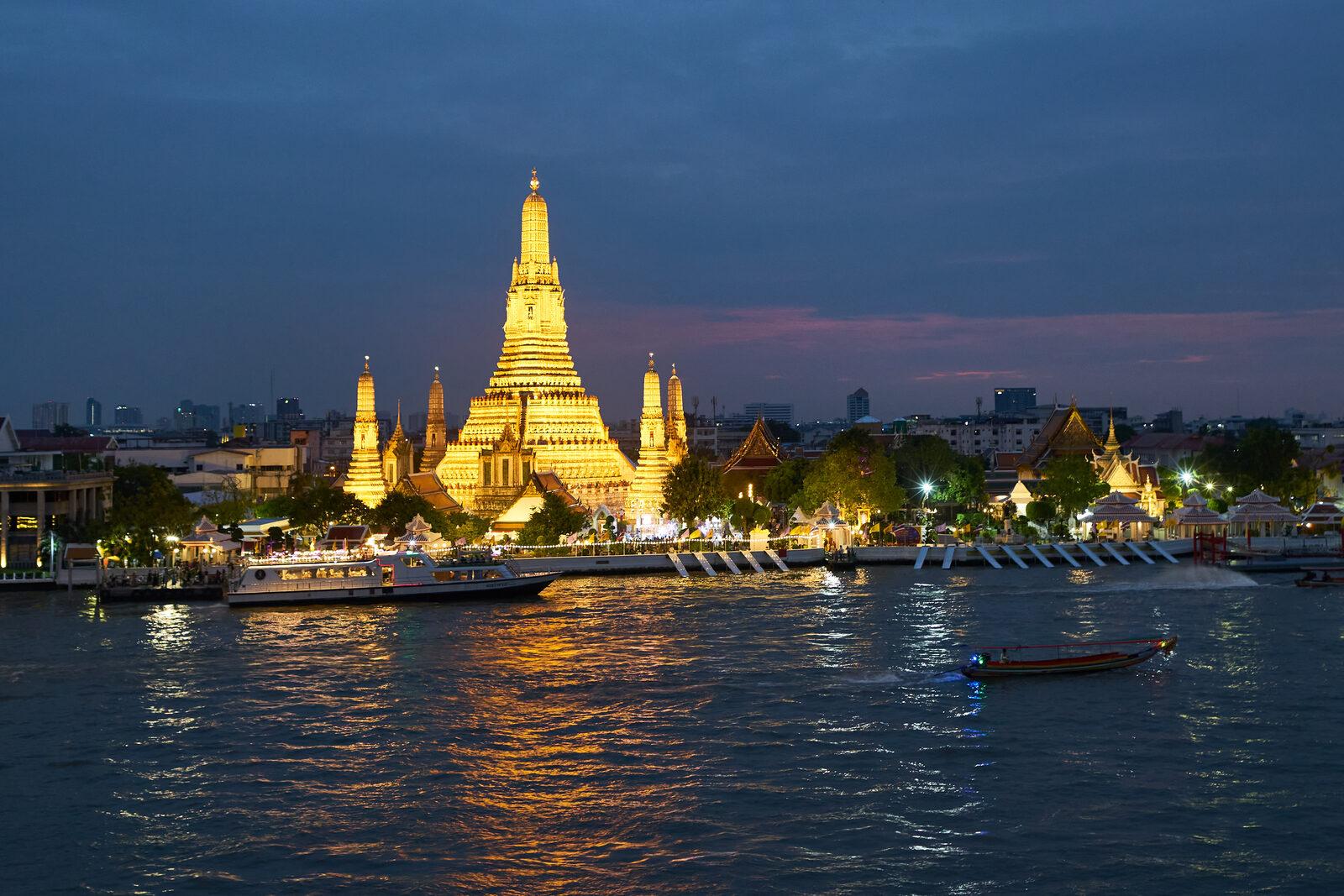 Wat Arun lit at dusk on the Chao Phraya — Bangkok’s signature view
